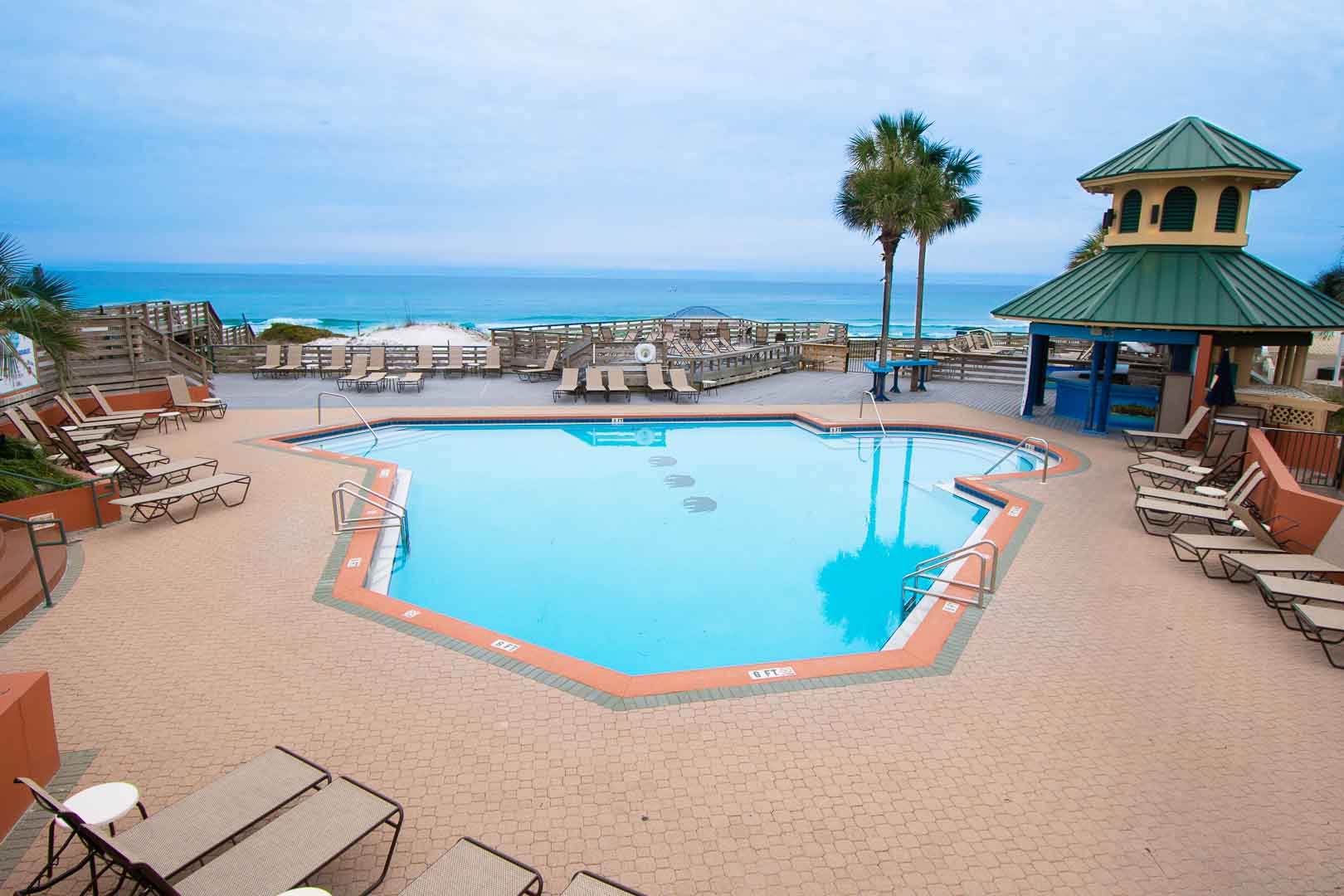 A spacious outdoor swimming pool with an ocean view at VRI's Bay Club of Sandestin in Florida.